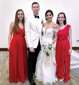 Bride and groom, flanked by two women, pose for the camera